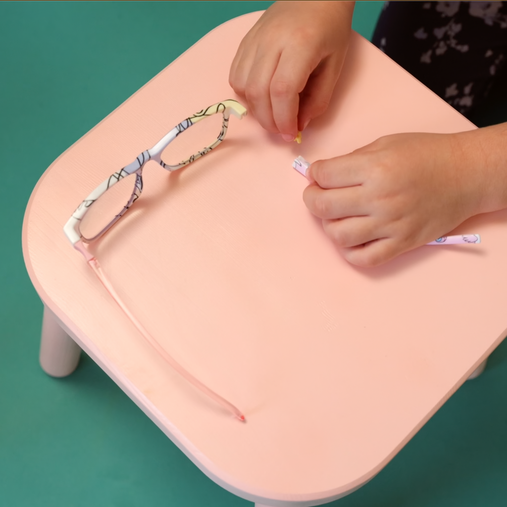 Kid building MEsquad glasses to show how to assemble the frames with hinges and temples