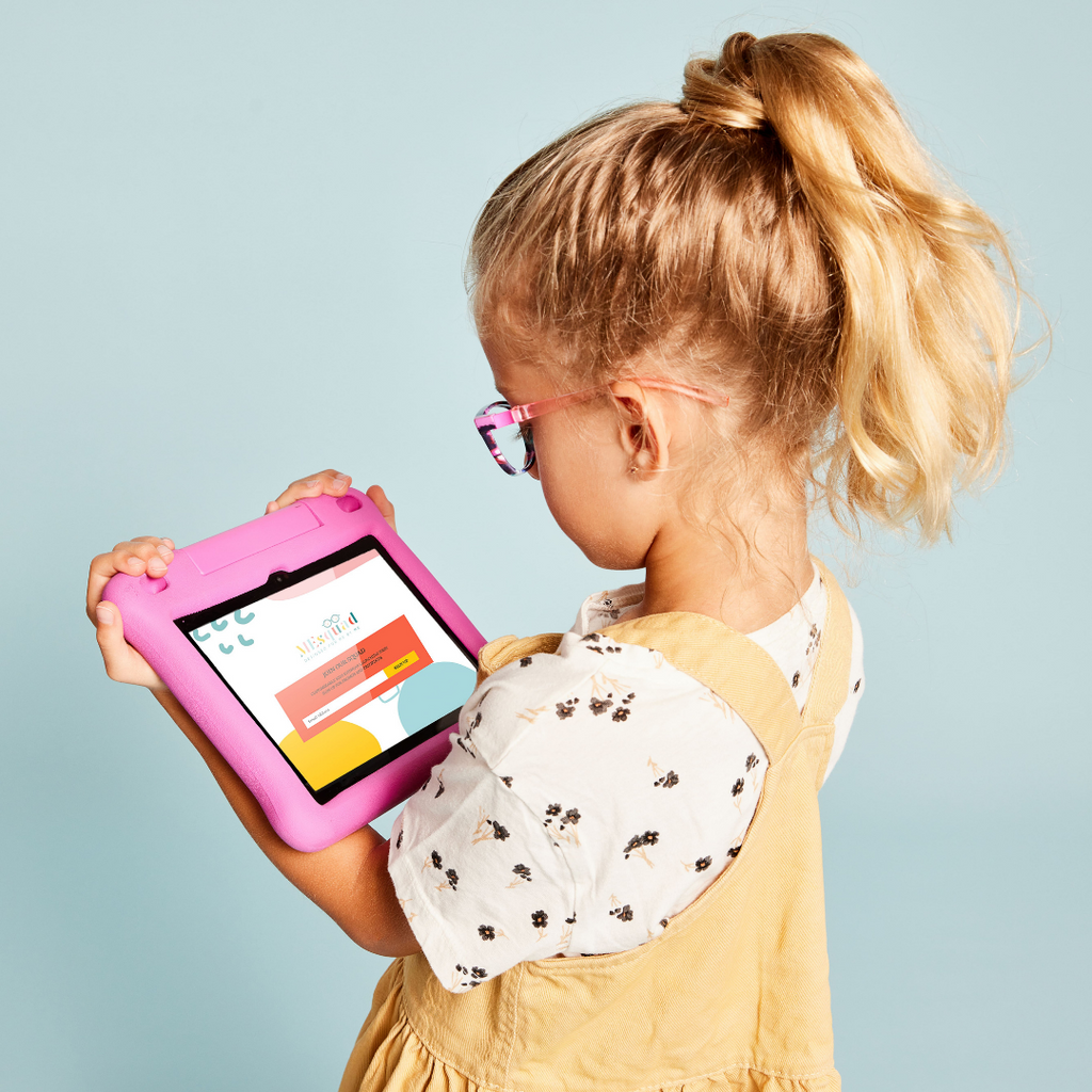 Blonde child with blue background holding pink tablet
